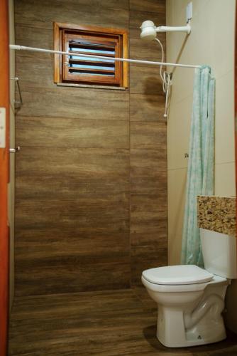 a bathroom with a toilet and a window at Casa de Serra Vila Viçosa in Viçosa do Ceará