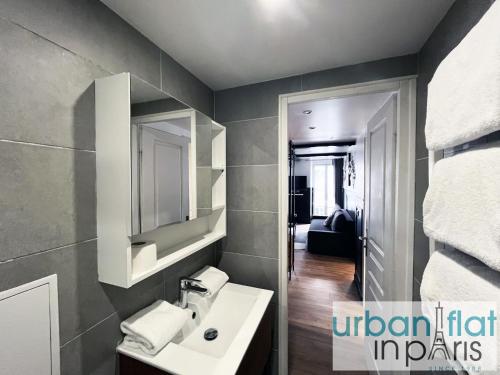 une salle de bain avec un lavabo et un miroir dans l'établissement Urban Flat 13 - Pretty 2 Bedroom Parisian Flat, à Paris