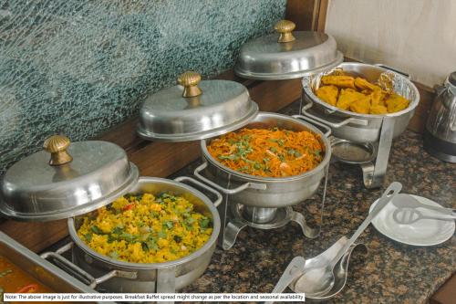 a group of pots of food sitting on a counter at Treebo Kamal Regency in Bhopal