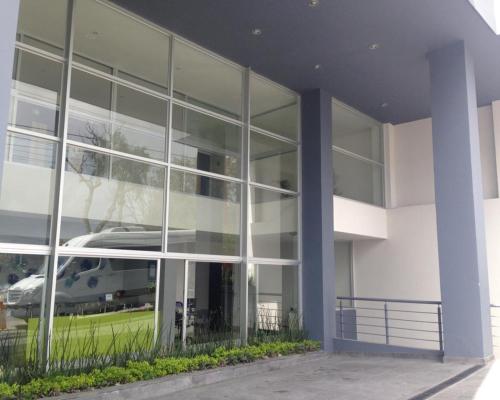 a large glass building with a car reflection in it at Hotel Misión Express Xalapa in Xalapa