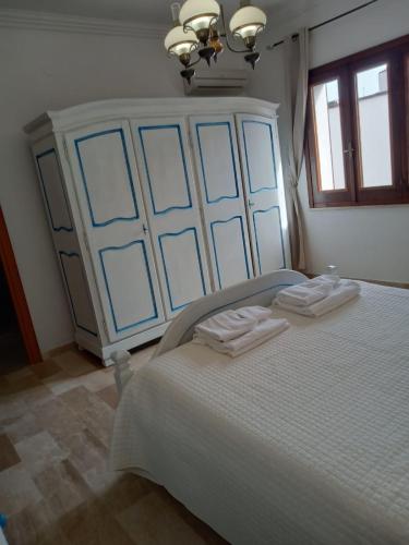 a bedroom with a large bed with two folded towels at Villa Nuragica Sardegna in Bacu Abis
