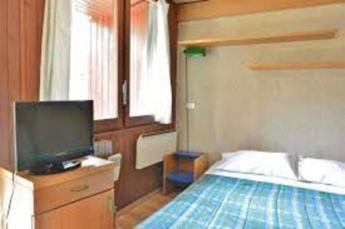 a bedroom with a bed and a flat screen tv at Condominio La Grand'Ourse - Cervinia in Breuil-Cervinia