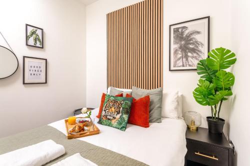 a bedroom with a bed with colorful pillows at Seabreeze Hideaway By Kozmo - Cozy 2-Bed Bungalow in Brighton near the Beach With Free WiFi & Terrace by Kozmo Properties in Brighton & Hove