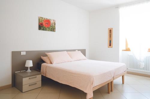 阿科Appartamenti Maso Giare的卧室里有一张床，墙上挂着一幅红花的图画