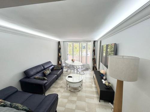 un salon avec un canapé et une table dans l'établissement Appartement chaleureux avec balcon - Champigny, à Champigny-sur-Marne