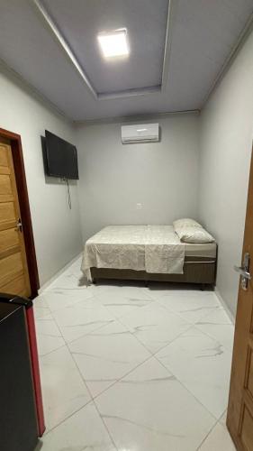 a bedroom with a bed and a flat screen tv at espaço R&H in Macapá