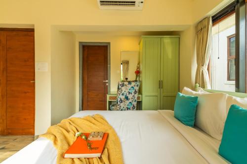 a bedroom with a white bed with a red tray on it at ELIVAAS 3 BHK Pool & Bar - Villa Judiline in Goa