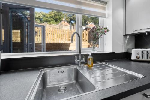 a kitchen counter with a sink and a window at Minutes from the port of Dover, free WiFi, free offroad private parking and rated a guest favourite on Air b nb! in Kent