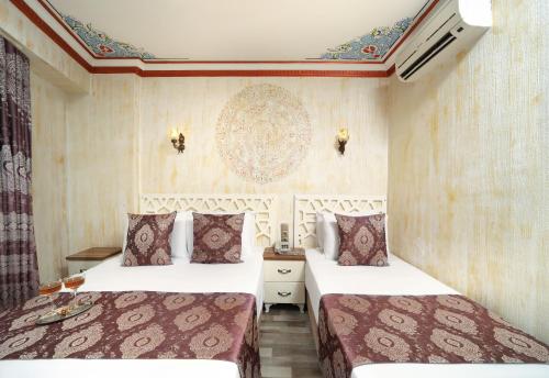 two beds in a hotel room with two beds sidx sidx sidx at Aldem Hotel in Istanbul