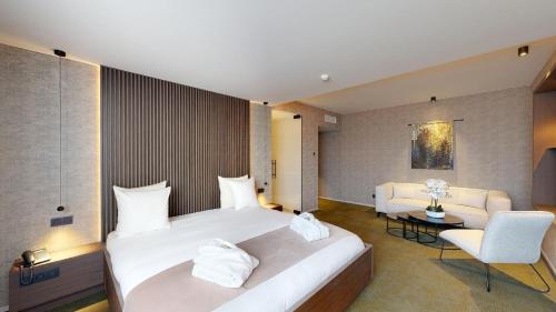 a hotel room with a large bed and a chair at Van der Valk Hotel Mons Congres & Spa in Mons