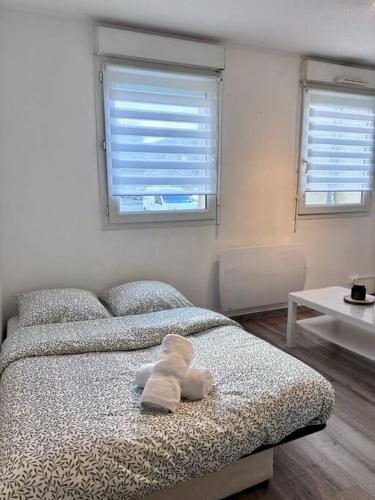 une chambre avec un lit avec des serviettes dessus dans l'établissement Le petit citadin, à Arras
