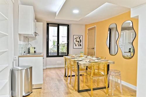 une cuisine avec une table à manger et des chaises en or dans l'établissement Appartement 3 chambres Paris 2ème - II, à Paris