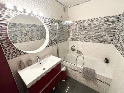 a bathroom with a sink and a tub and a mirror at Appartement confort avec balcon - Champigny in Champigny-sur-Marne