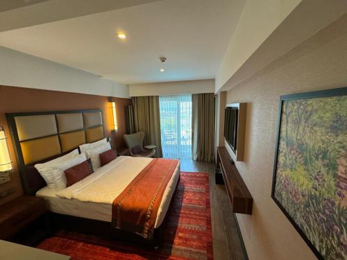 a hotel room with a bed and a large window at Sile Gonen Hotel in Sile