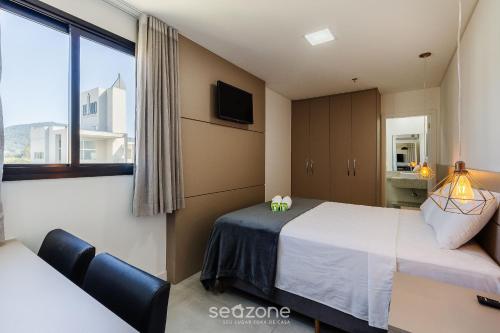 a hotel room with two beds and a window at MHF II - Apts Variados em Prédio com Vista para o Mar em Itapema in Itapema