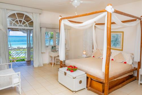 a bedroom with a canopy bed with a view of the ocean at Hotel Villa Serena in Las Galeras
