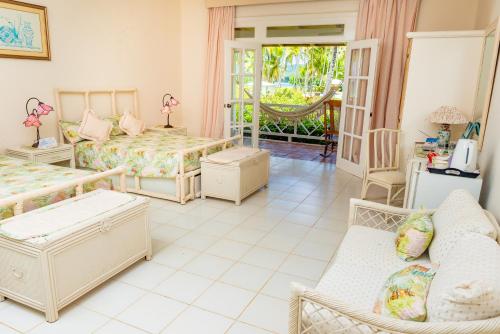 a bedroom with beds and a living room with a couch at Hotel Villa Serena in Las Galeras