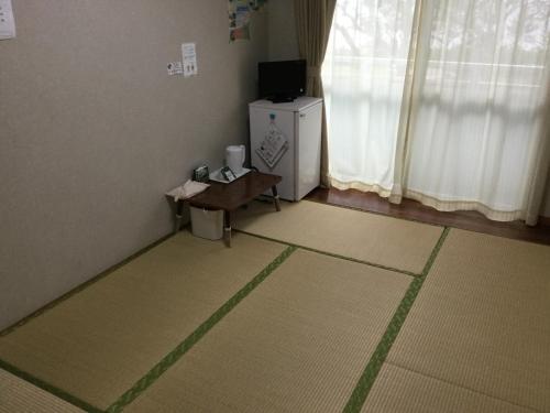 a room with a small refrigerator and a table at Uminoie Painukaji in Iriomote