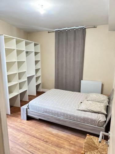 - une chambre avec un lit et des étagères blanches dans l'établissement Appartement au centre ville, à Salies-de-Béarn