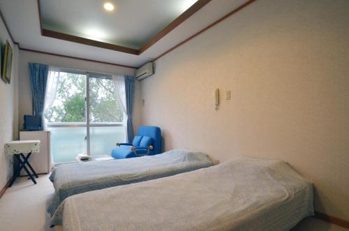 a hospital room with two beds and a blue chair at Uminoie Painukaji in Iriomote