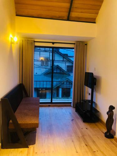 a living room with a couch and a large window at R21 Nuwara Eliya in Nuwara Eliya