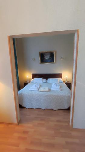a bedroom with a large white bed with two lamps at Batthyány Kastélyszálló in Zalacsány
