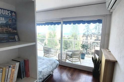- une chambre avec une grande fenêtre donnant sur un balcon dans l'établissement Terrasses de la Corniche, 2p 65m2 spacieux, terrasses mer & montagne, piscine et parking privé, à Nice