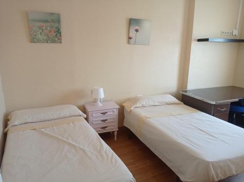 a room with two beds and a dresser and a desk at Casa de la Ermita in Alhaurín de la Torre