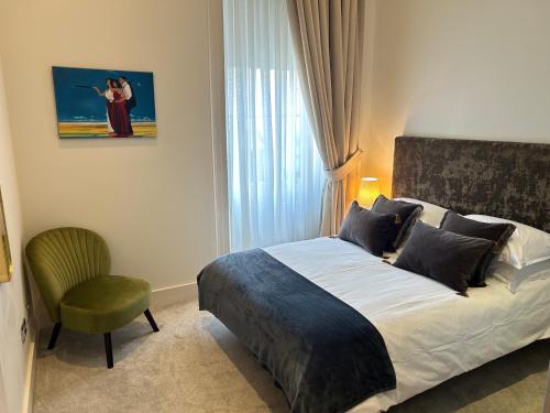 a bedroom with a bed and a chair and a window at Perfect In The Park in Glasgow