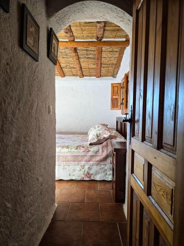 a bedroom with a bed in a room with a ceiling at Casas Rurales La Tejeruela in Yeste