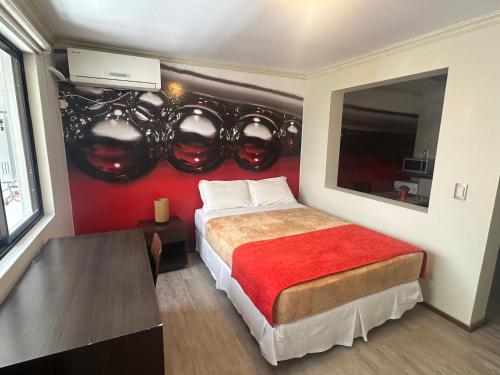 a bedroom with a bed with a red wall at Edificio Terravina in Tarija