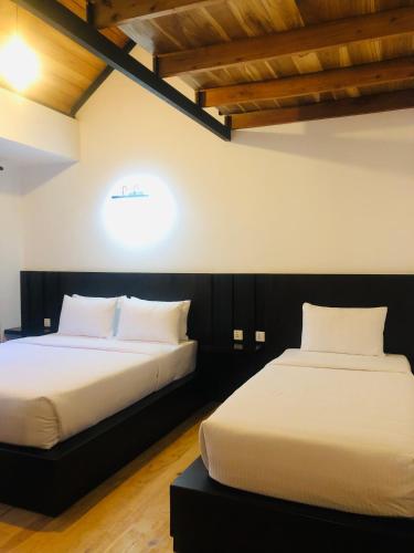 two beds sitting next to each other in a room at R21 Nuwara Eliya in Nuwara Eliya