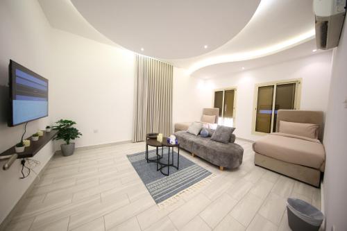 a living room with a couch and a tv at Stay easy Obhur - ستاي ايزي in Obhor