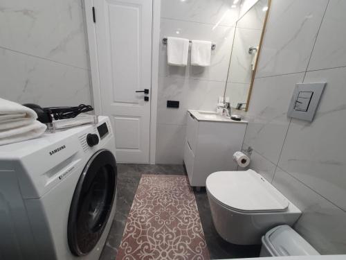 a bathroom with a washing machine and a toilet at Riviera apartment for 6 persons in Almaty