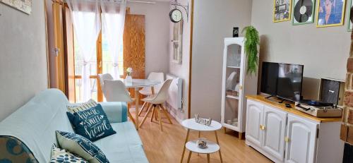 ein Wohnzimmer mit einem blauen Sofa und einem Fernseher in der Unterkunft Mirador de Bergosa VU-HUESCA-20-111 in Castiello de Jaca