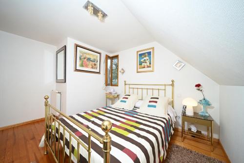 a bedroom with a bed with a striped blanket at Jolie Maison Vallee D'aure 4étoiles in Pailhac