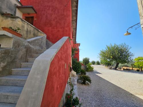 una rampa di scale accanto a un edificio rosso di Tenuta degli Ulivi - Dimora Contadina a Montecorvino Rovella