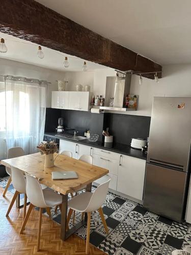 une cuisine avec une table en bois et un réfrigérateur dans l'établissement Appartement Carmes, hypercentre, à Toulouse