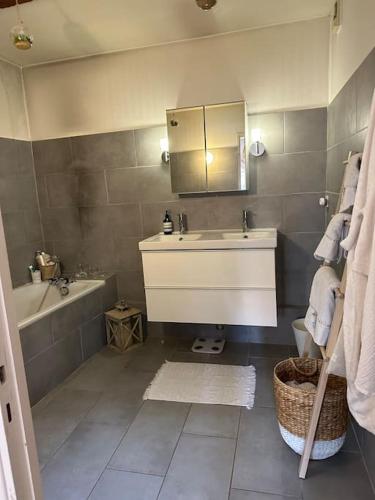 une salle de bain avec un lavabo, une baignoire et un miroir dans l'établissement Appartement Carmes, hypercentre, à Toulouse