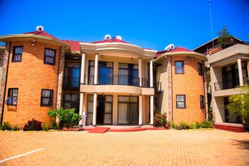 a large brick building on a brick driveway at Quality Inn Hotel Kigali in Kigali