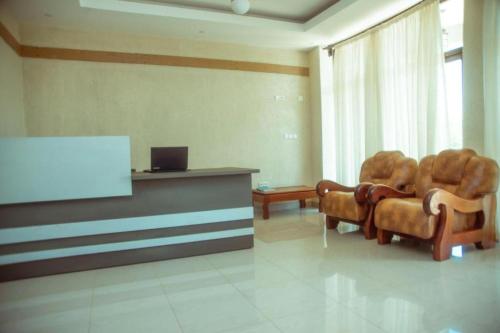 a waiting room with two chairs and a screen at Quality Inn Hotel Kigali in Kigali
