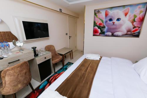 a room with a bed and a desk and a tv at Horizon Pyramid View INN in Cairo