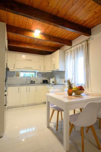 a kitchen with a white table and white chairs at LIVAS Residence in Tympáki