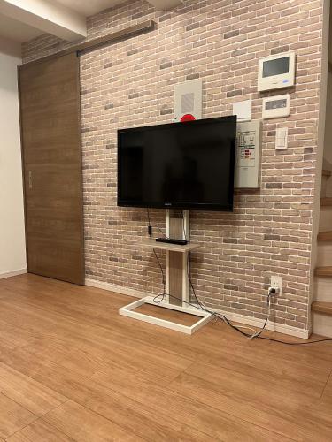 a flat screen tv hanging on a brick wall at Miaoyi Asakusa in Tokyo