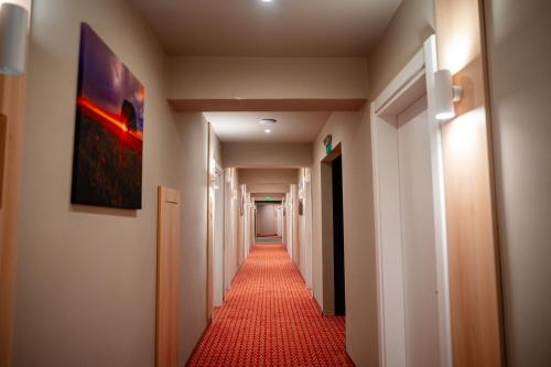 a long hallway with a red carpet in a building at Bacolux Santis, Covasna in Covasna