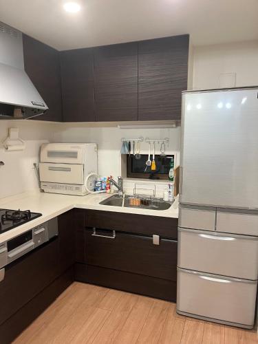 a kitchen with a refrigerator and a sink at Miaoyi Asakusa in Tokyo