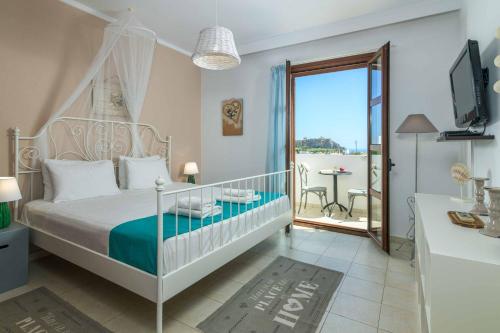 a bedroom with a bed and a balcony with a table at Lindos Topaz in Lindos