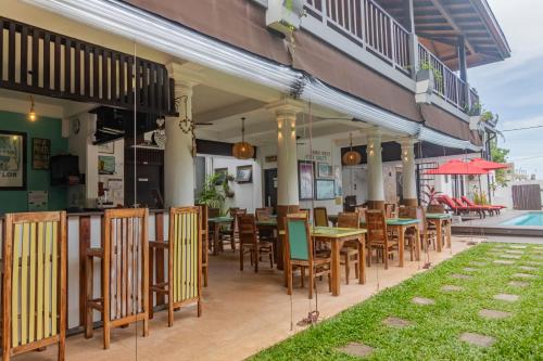 a restaurant with tables and chairs on a patio at Lion's Rest in Weligama