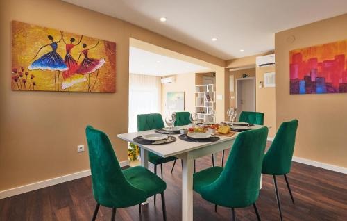 a dining room with a table and green chairs at Cozy Home In Gornja Stubica With Sauna in Gornja Stubica
