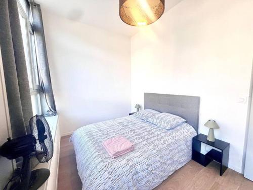 a bedroom with a bed with a pink towel on it at Élégant T3 centre-ville in Cluses